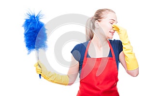 Young cleaning maid pinching her nose