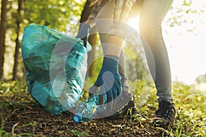 Young cleanup volunteer collecting trash in the forest