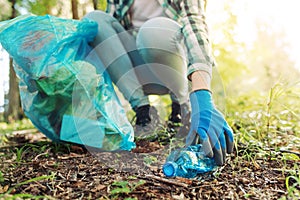 Young cleanup volunteer collecting trash in the forest