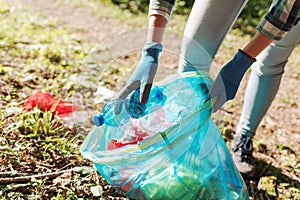 Young cleanup volunteer collecting trash in the forest