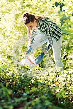 Young cleanup volunteer collecting trash in the forest