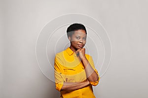 Young clever thinking African American woman standing on white background