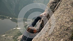 Young climber climbing a high mountain.