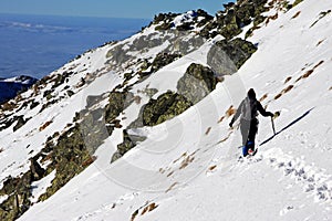 Young climber trekking through deep snow in Retezat mountains, Romania