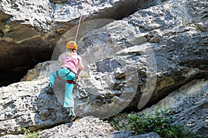 Young climbing girl on a rock wall