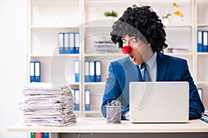 Young clown businessman working in the office