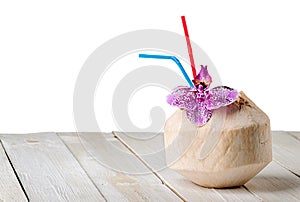 Young coconut with orchid flower on wooden table