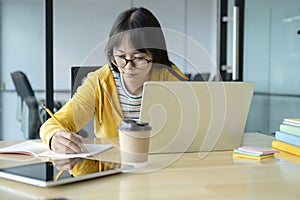 Young collage student using computer and mobile device studying online