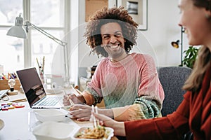 Young colleagues having lunch time in their office.