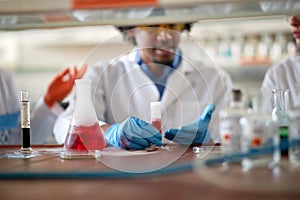 Young colleagues in a protective gear discuss about an experiment they doing in the university laboratory. Science, chemistry, lab