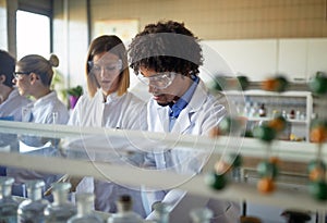 Young colleagues in a protective gear focused on the work with chemicals at the university laboratory. Science, chemistry, lab,