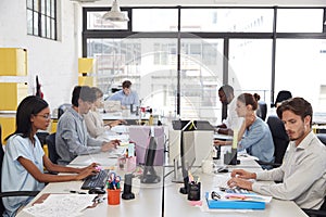 Young colleagues working in a busy open plan office