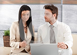 Young colleagues working on laptop