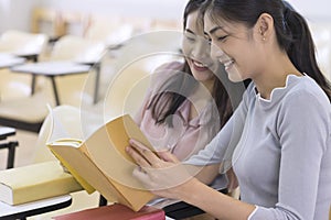 Young college students reading a book together in class. Education and school concept.