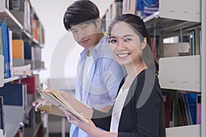 Young college students reading a book together in library. Education and school concept.