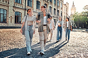 Young college students walking on campus after classes.