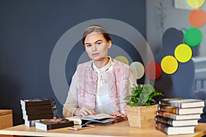 Young college woman sitting at table in campus cafe reading new book series