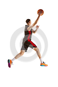 Young competitive guy, basketball player in uniform playing, training isolated over white background. Full-length. Sport