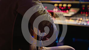 Young composer songwriter recording his guitar tunes in professional studio