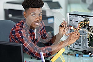 Young computer engineer connecting cables