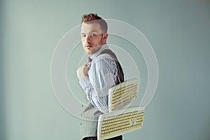 Young computer geek carrying keyboards underhand