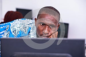 Young concentrated businessman working with laptop in office