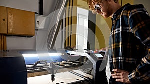 Concentrated worker operate CNC machine on factory