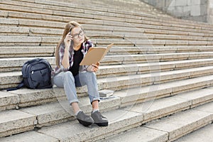 Young student girl making notes in notebook