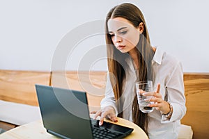 Young concentrated girl working on laptop.