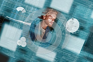 Young concentrated red haired data analyst looking over the data