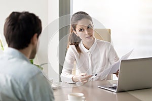 Young confident businesswoman discussing resume with male candid