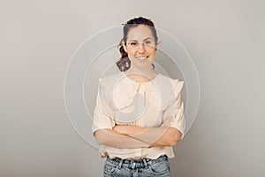 Young confident handsome smiling woman is standing with arms crossed.
