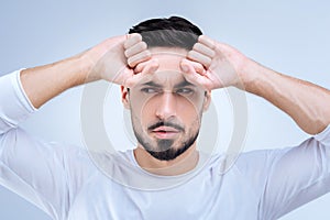 Young confident man having a suspicion about the strange situation at work