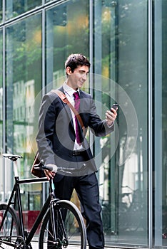 Young confident man talking on mobile phone after bike commutin