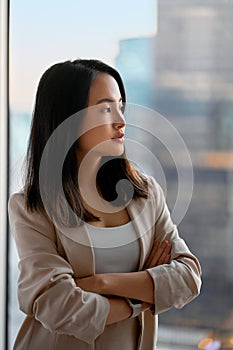 Young confident proud Asian business woman executive looking at window.