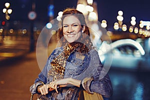 Young confident urban woman toothy smile on bridge at night