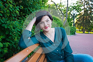 Young confident woman is smiling while relaxing on a bench