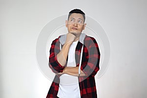 Young confused Asian man thinking expression, looking up contemplation gesture over white