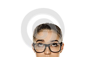 Young confused woman with glasses looking up