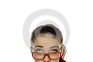 Young confused woman with glasses looking up