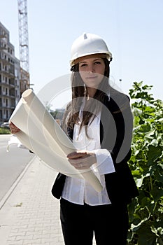 Young construcion worker holding plans