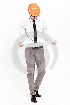 Young construction engineer in orange helmet studying layout plan on white background