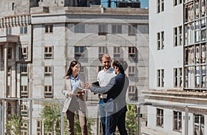 Young construction engineers discussing project while standing on a construction site in the city