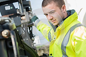 Young construction manager or building site foreman worker outside