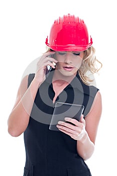 Young construction manager calling and using tablet isolated