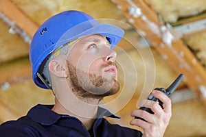 young construction worker holding walkie talkie