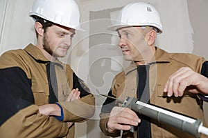 Young construction worker installing window in house