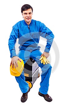 Young construction worker sitting on his toolbox
