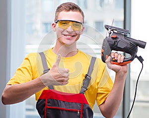 Young construction worker in yellow coveralls