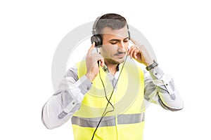 Young constructor or engineer listening music on headphones
